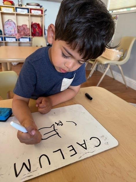 A child tracing letters and learning in pre-K program