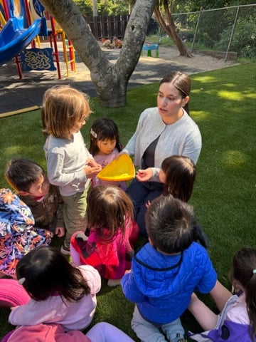 Teacher teaching the kids outside about rolly polly