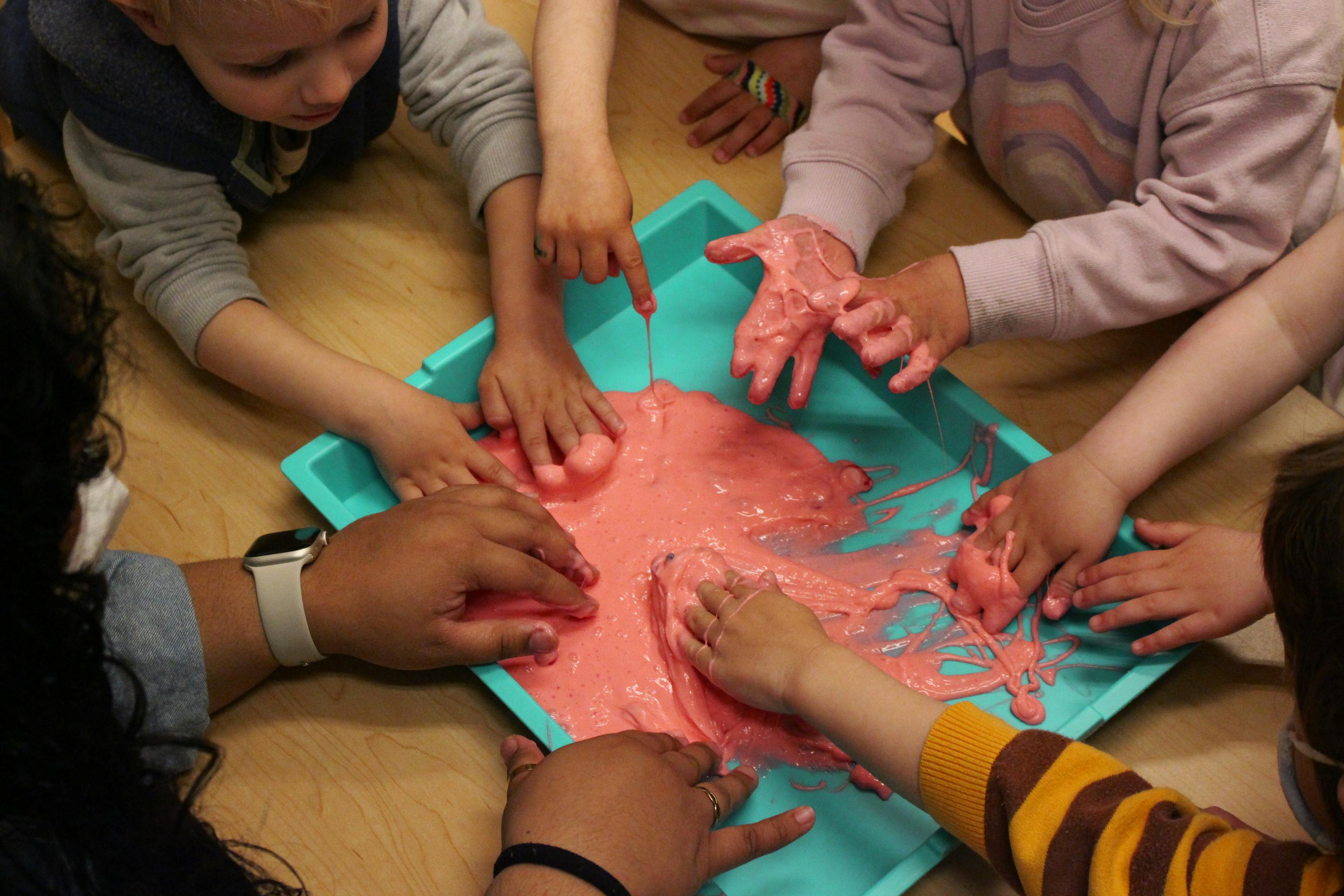 Children exploring textures together with pink sensory slime at Kids Konnect