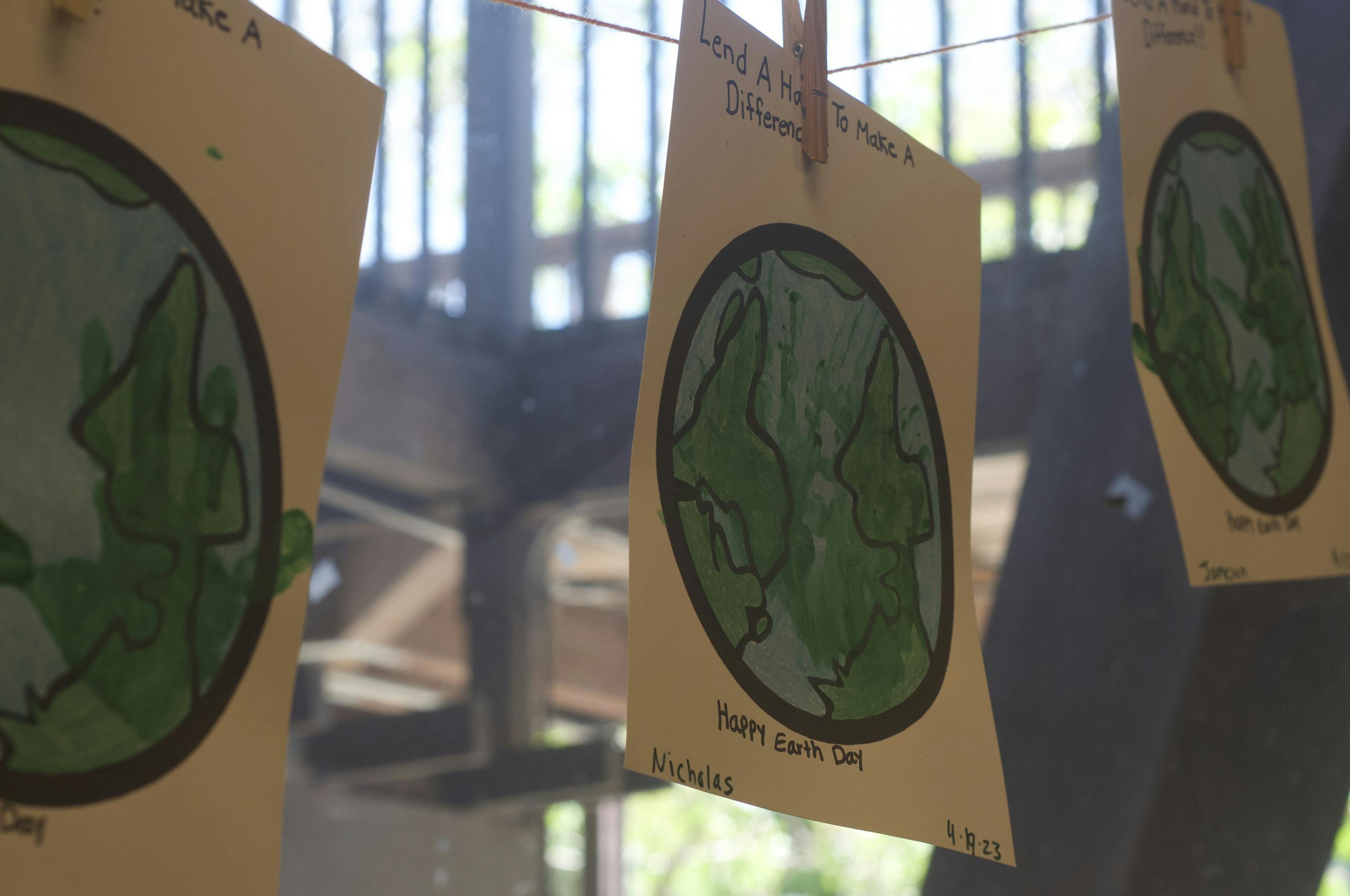 Preschool Earth Day paintings displayed on classroom window at Kids Konnect San Mateo