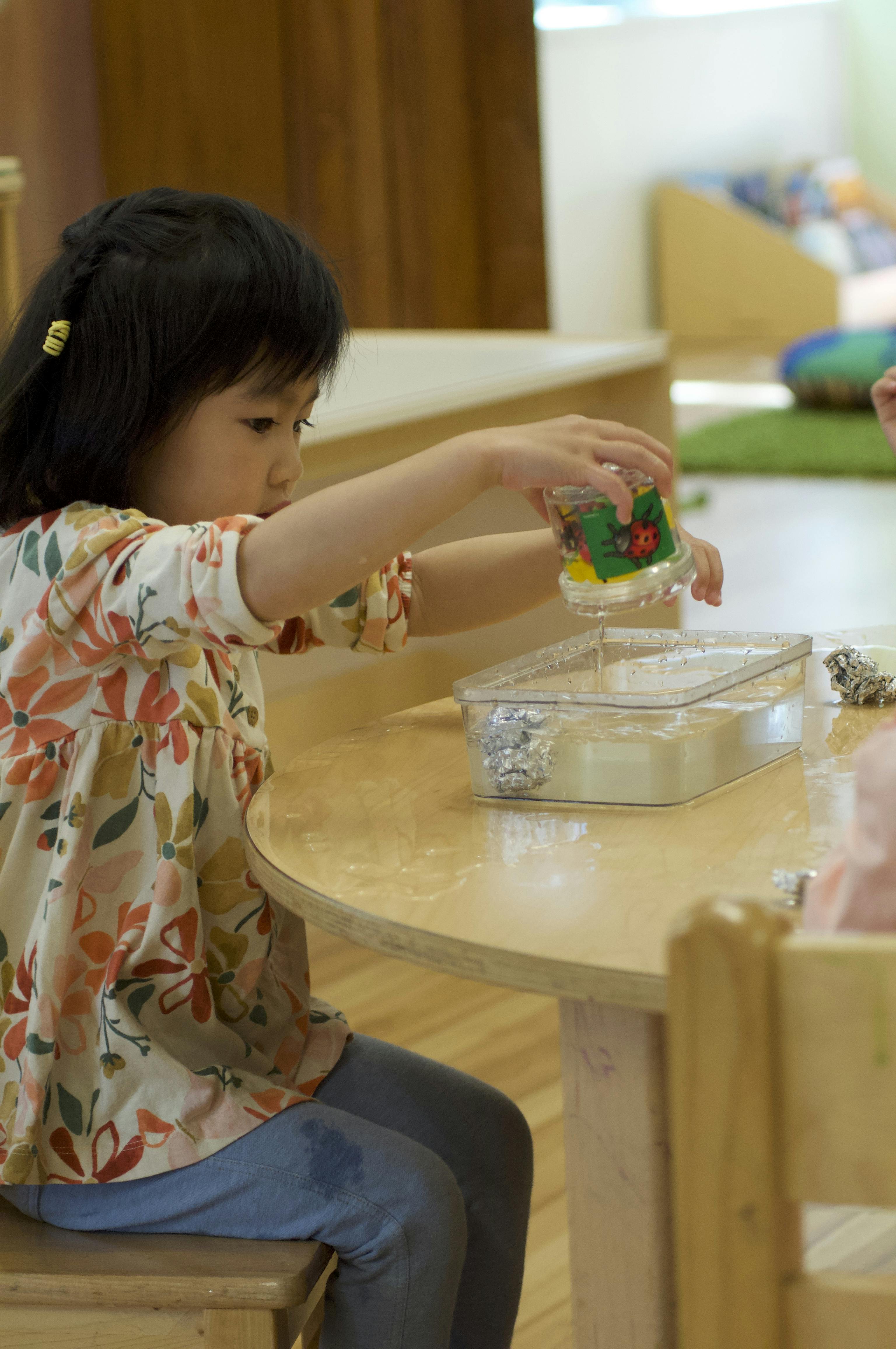 Toddler engaging in hands-on sensory science activity at Kids Konnect preschool