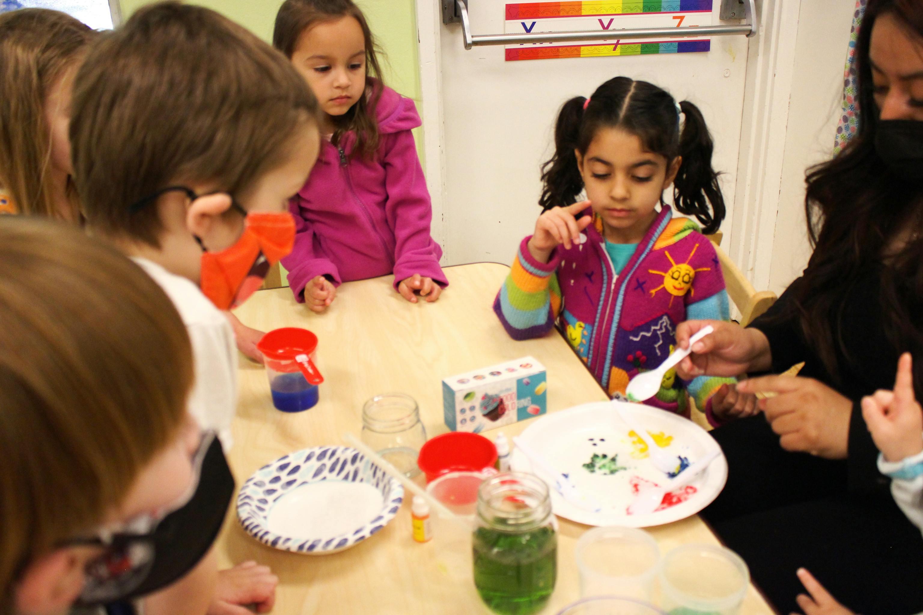 Preschoolers doing a guided color-mixing science activity with teacher at Kids Konnect San Mateo Downtown